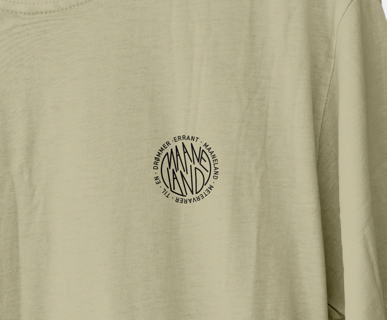 Nærbillede af ERRANT X MAANELAND T-shirt med rund hals og klassisk pasform, visende Maanelands og Errants logo samt teksten Metervarer Til En Drømmer.