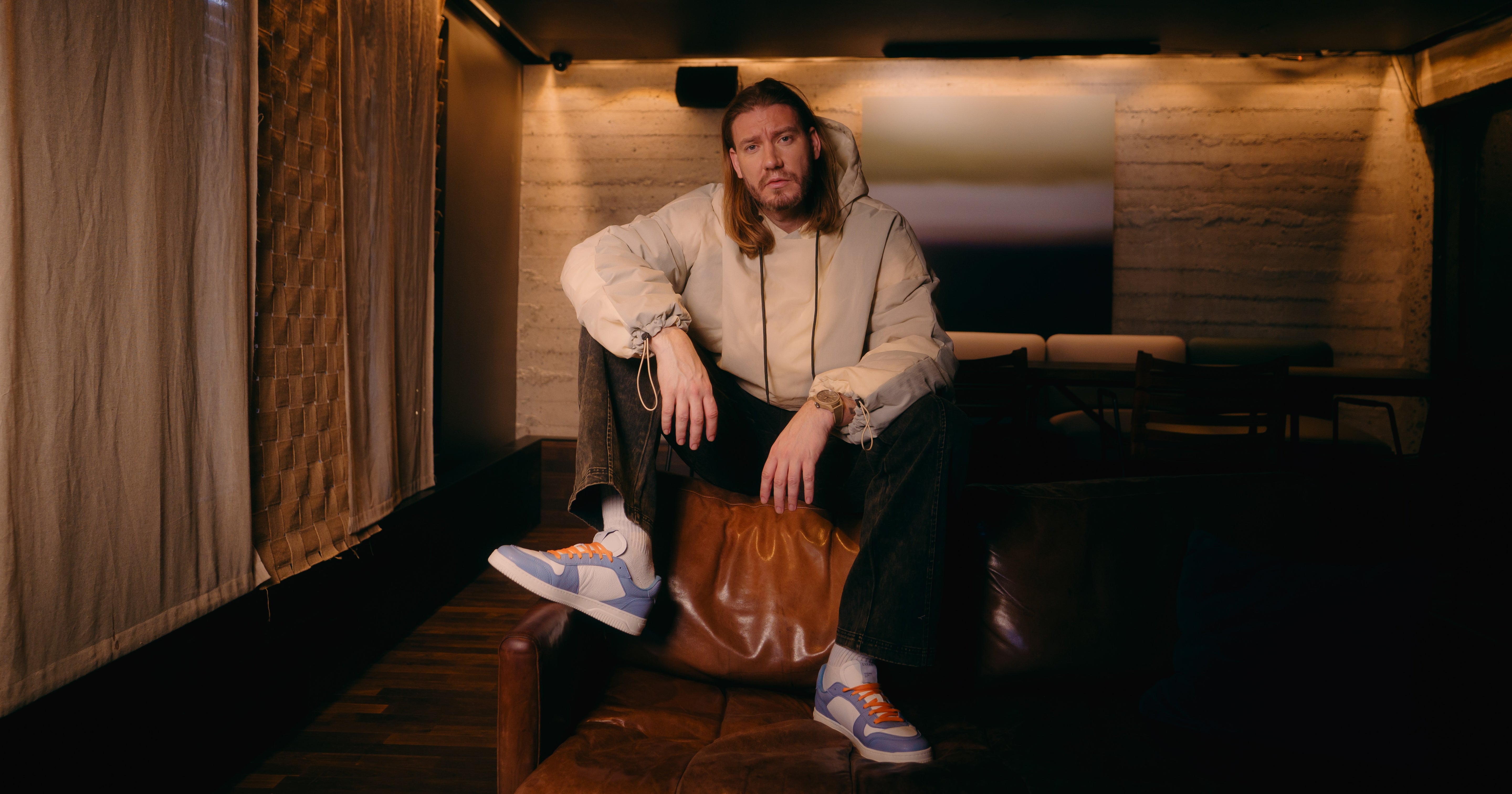 Nicklas Bendtner sidder i en sofa med Low Sneaker - Bubble Blue på