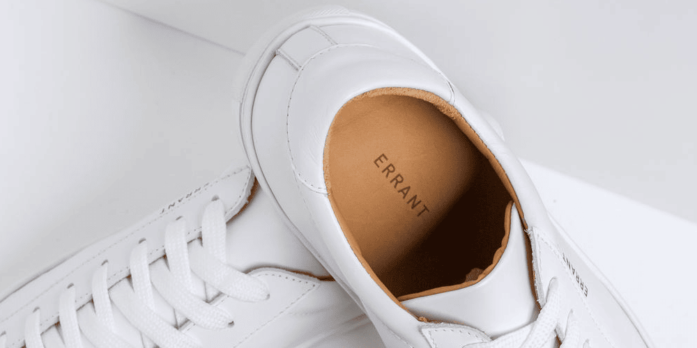 Hvide sneakers med mærket "ERRANT" i sålen.