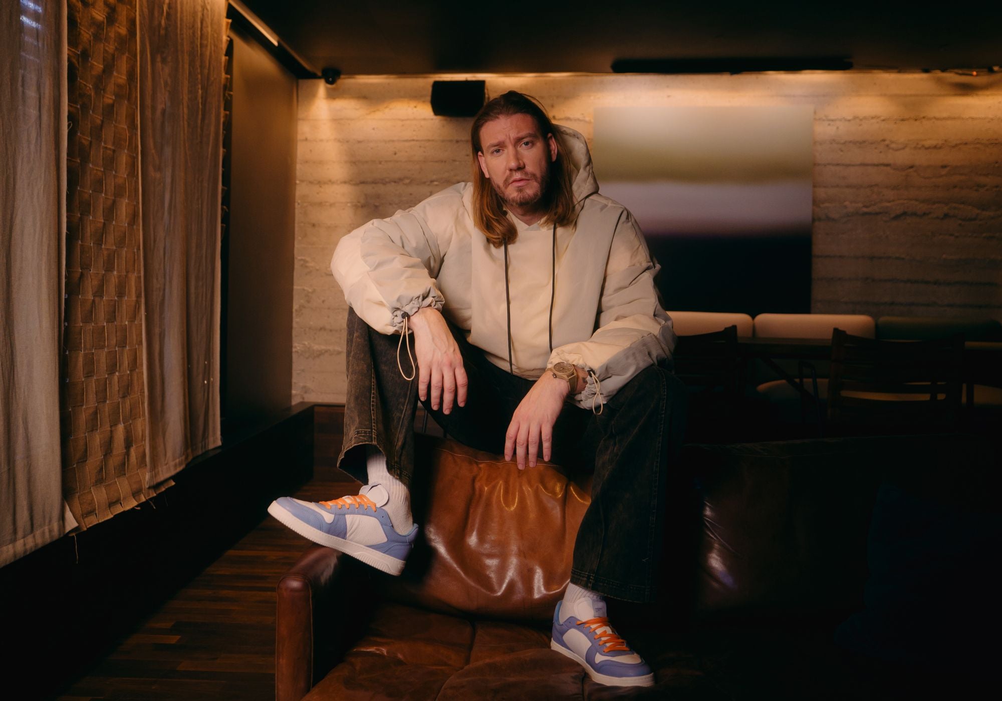Nicklas Bendtner sidder i sofa med et par Low Sneaker - Bubble Blue på