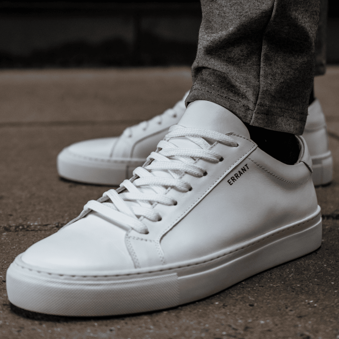 Hvide sneakers på fortov.