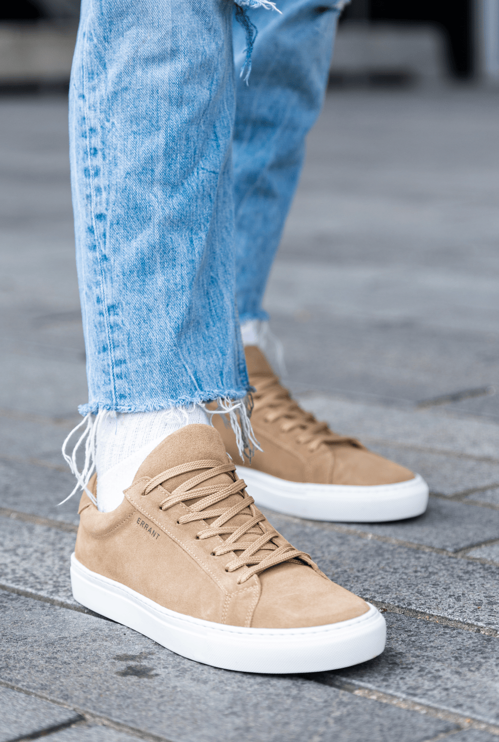 ALT tekst: Person iført beige sneakers og lyseblå jeans.