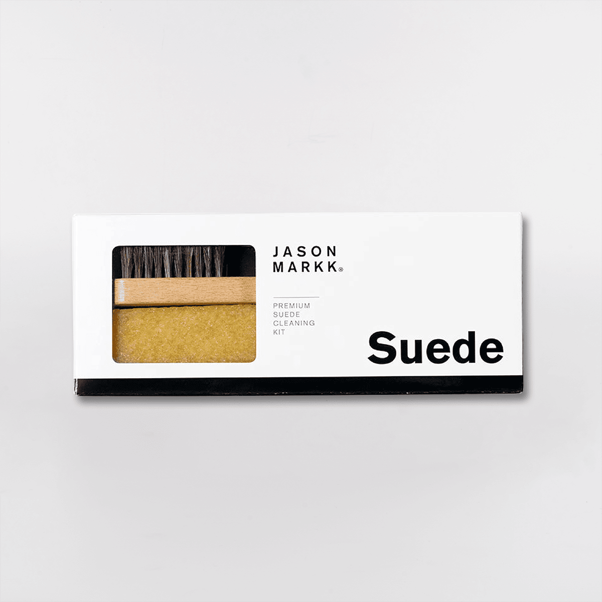 Billedet viser et Jason Markk Premium Suede Cleaning Kit, som indeholder en børste og en rengøringssvamp til ruskind.