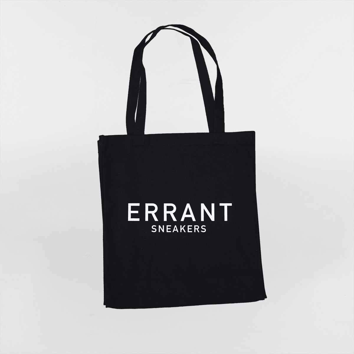 Sort mulepose med teksten "ERRANT SNEAKERS" trykt i hvidt på forsiden.